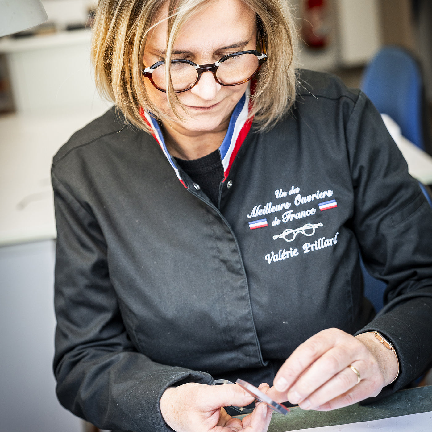 Morel prototypist Valérie Prillard working by hand on a frame at her workshop bench in her Meilleur Ouvrier de France coat