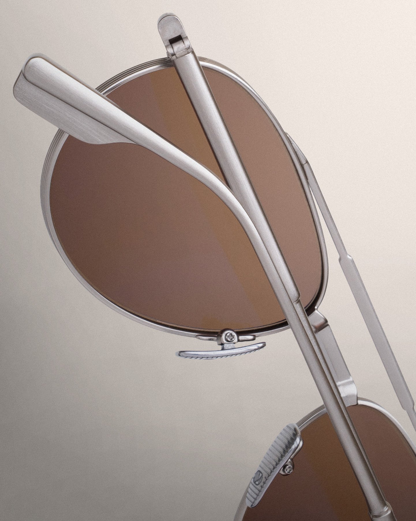 Close-up of UDM Bahia Palace eyewear with folded silver-toned temples, a sculpted hinge area, and patterned nose pads
