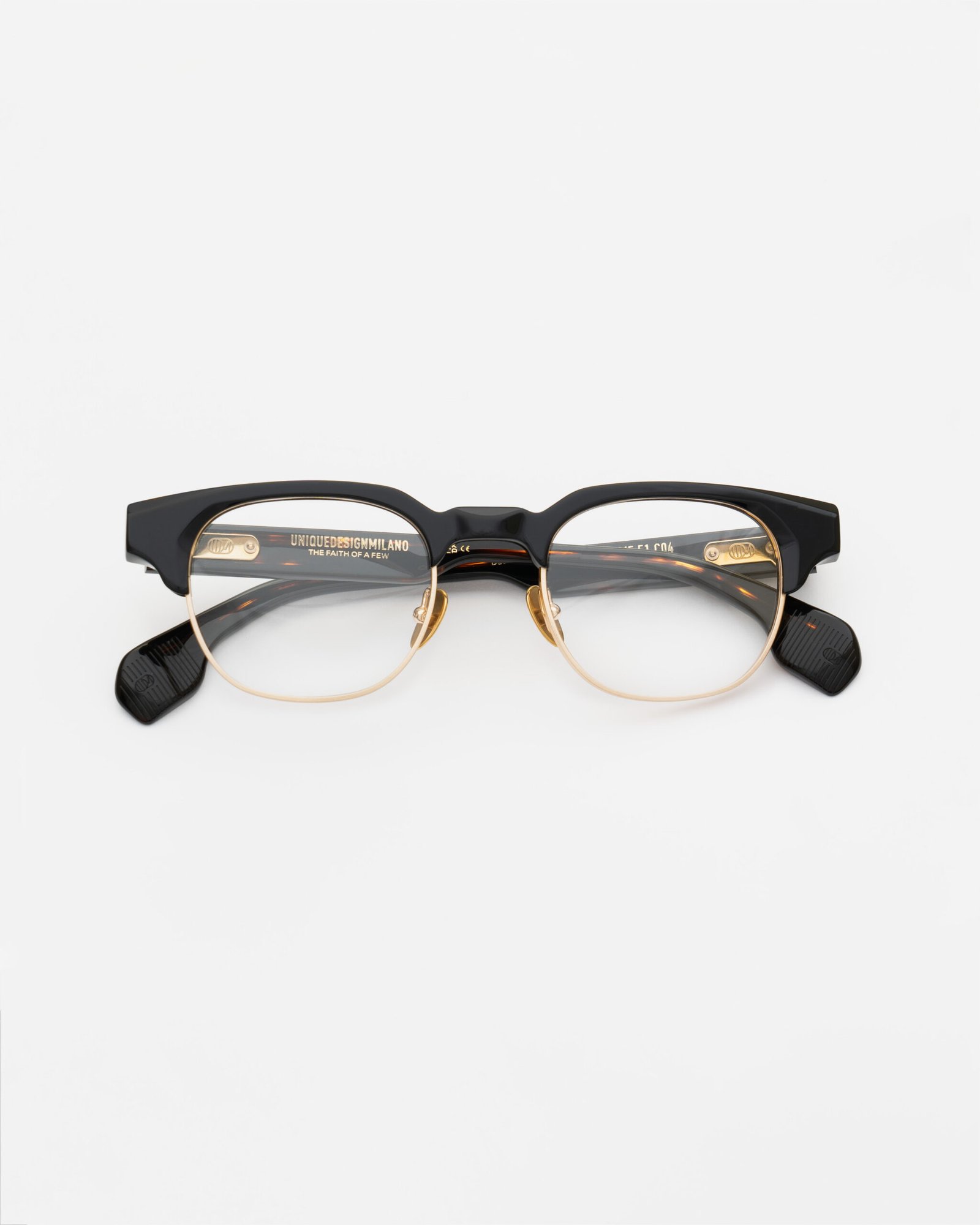 Front view of UDM FRAME 51 in black acetate with gold-toned lower rims and nose pads