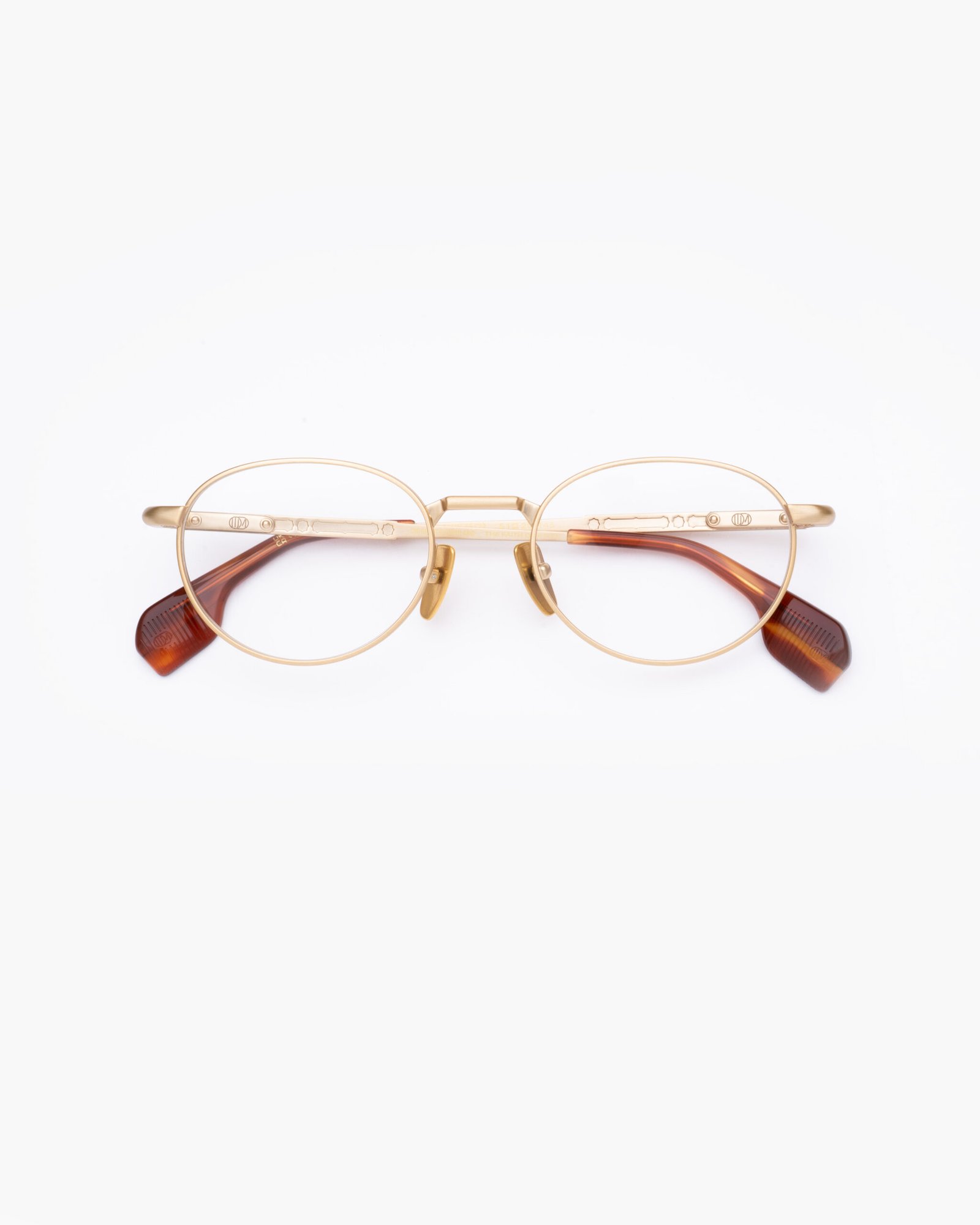 Front view of UDM FRAME 55 with gold-toned rounded titanium rims and tortoise acetate temple tips